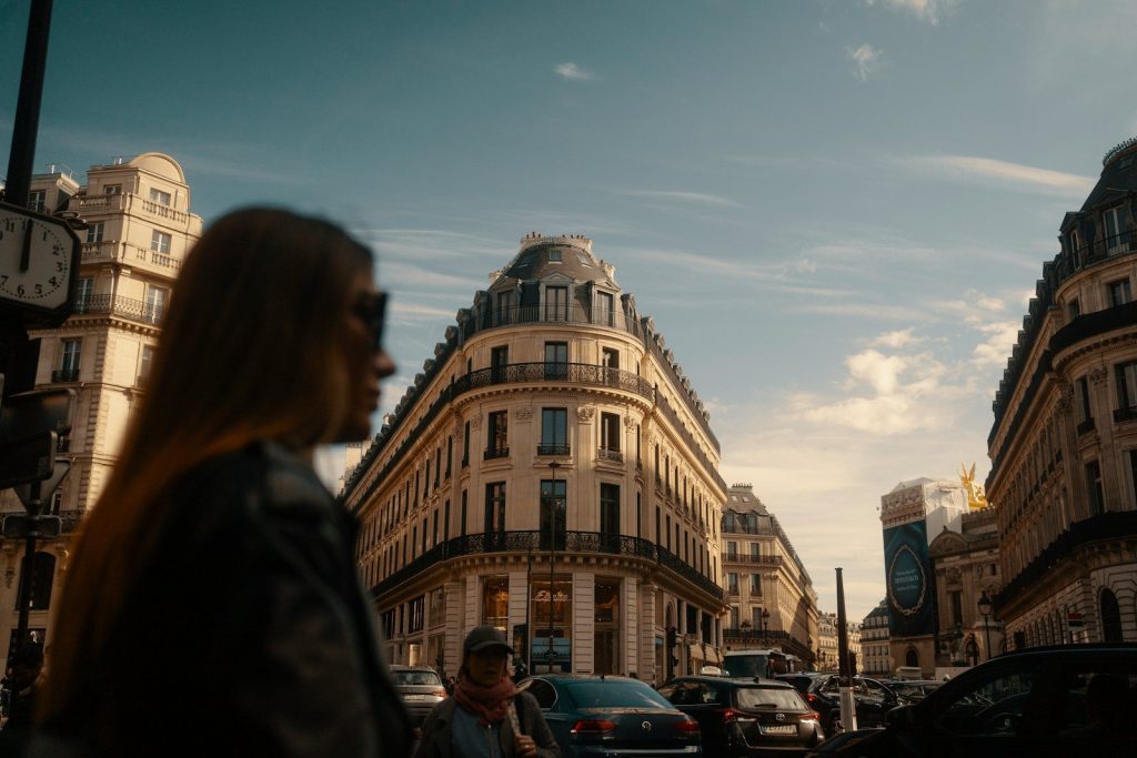 Woman walking on a parisian street with buildings.