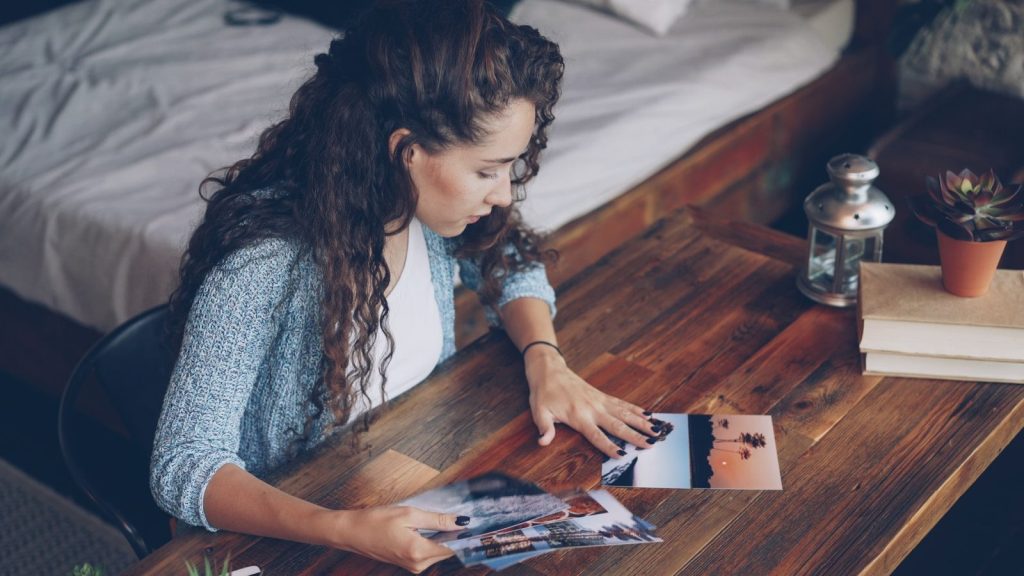 Woman looking at photographs on a wooden table
