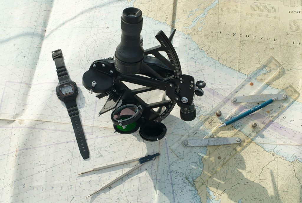 Sextant, watch, dividers, and ruler on map