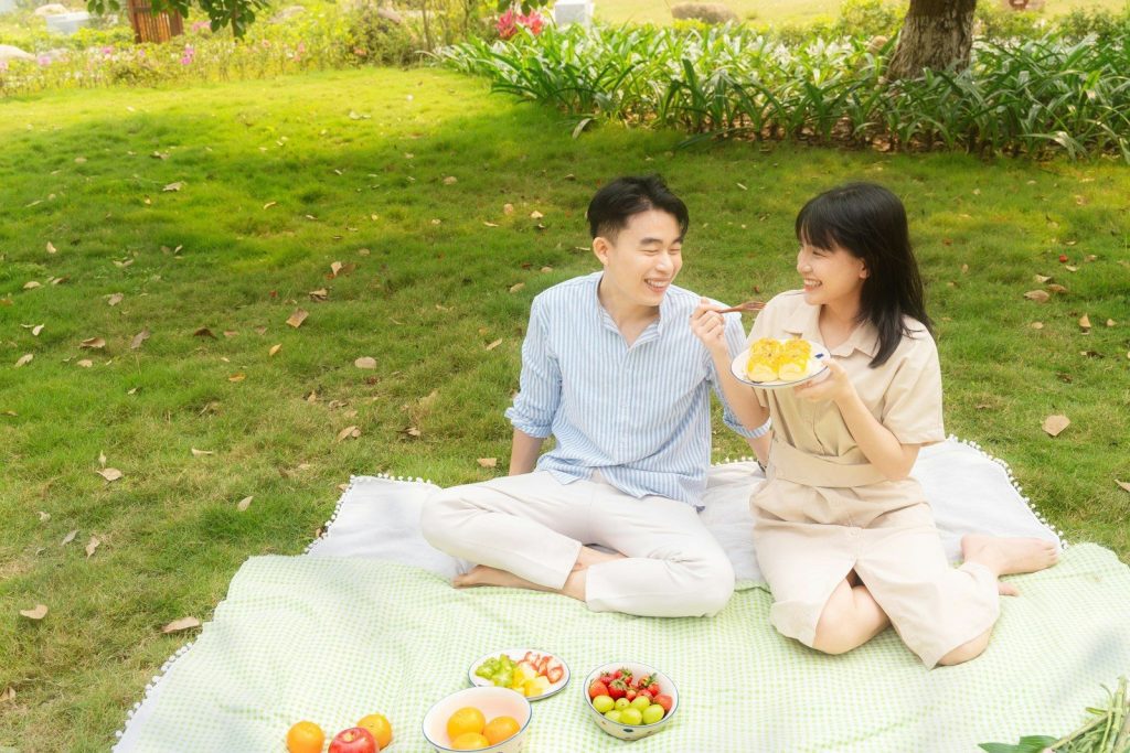 Couple enjoying a picnic with cake and fruit
