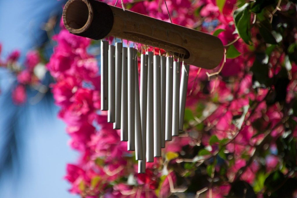 a metal wind chime hanging from a tree