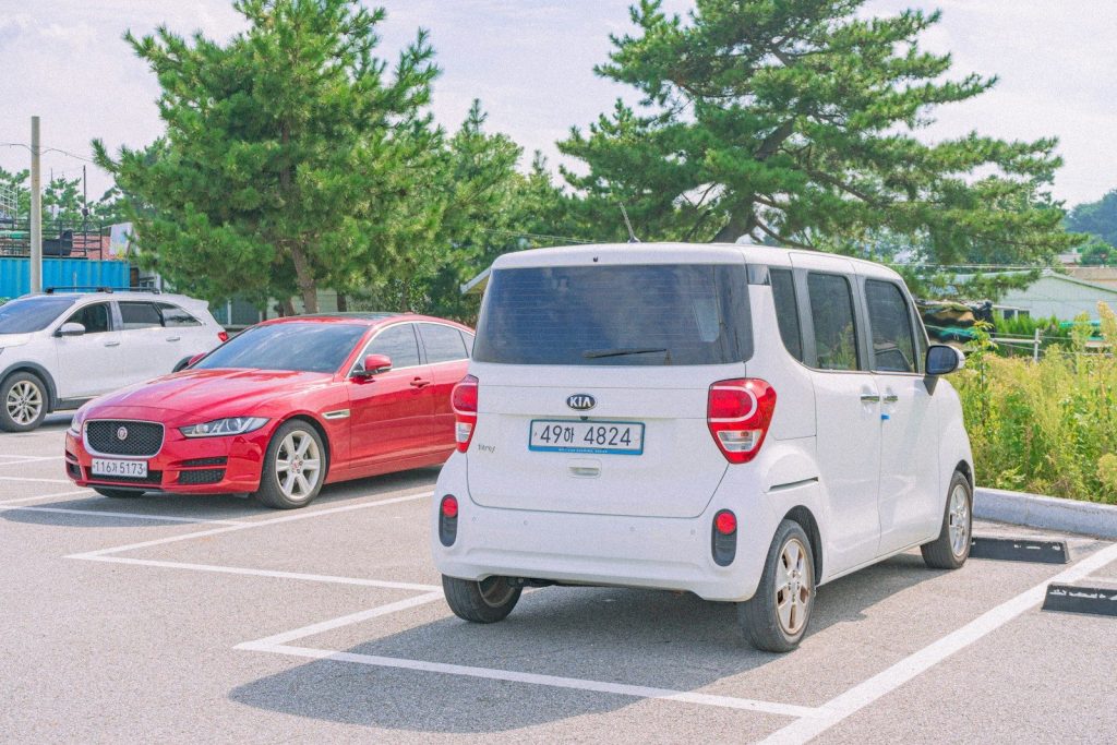 a white car parked next to a red car