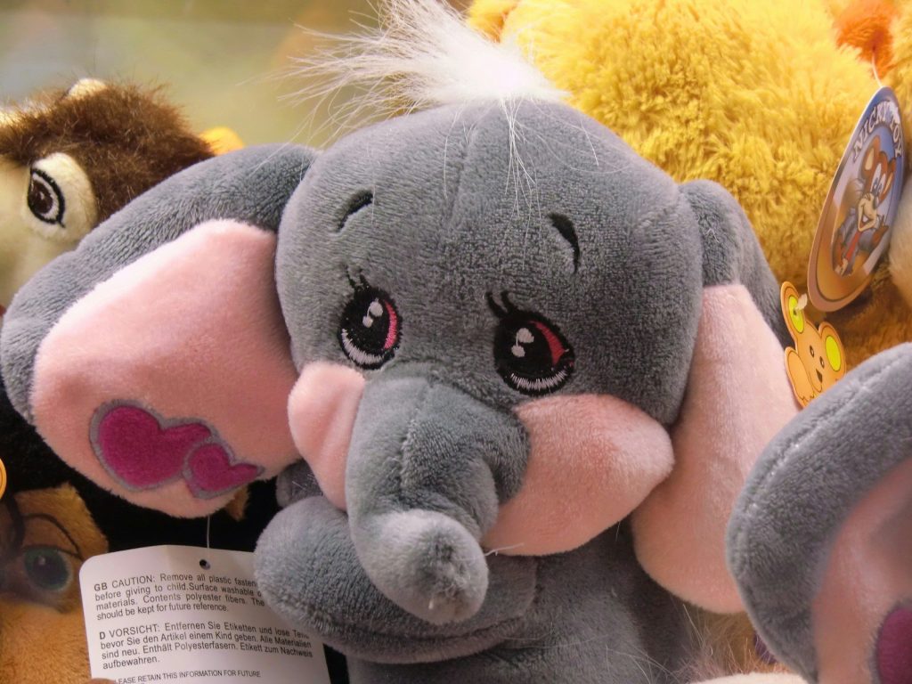 A cute stuffed elephant with big pink ears.
