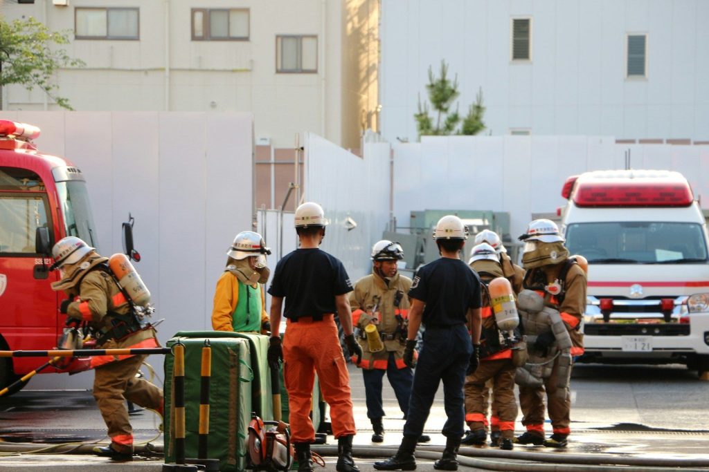 Firefighters and emergency personnel with a fire truck and ambulance.
