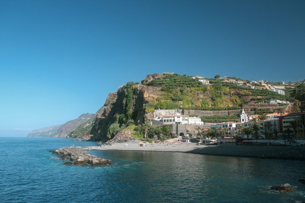 Coastal village nestled on a steep, green hillside.