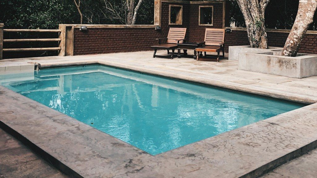 two lounge chairs near swimming pool