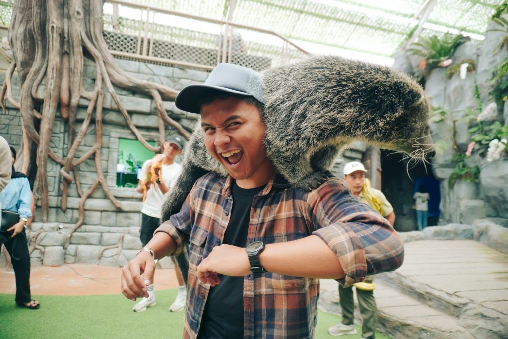 Man with a binturong on his shoulders