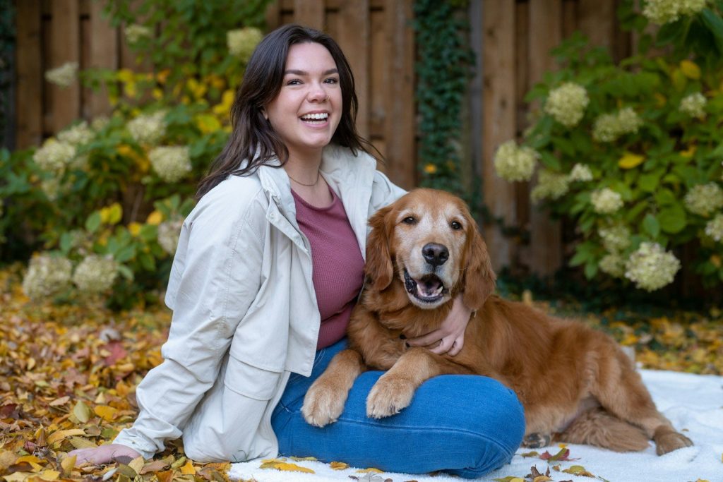 A woman sitting on a bean bag chair with her dog
