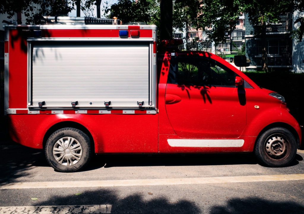 A small red truck parked on the side of the road