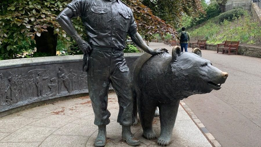 a statue of a man standing next to a bear
