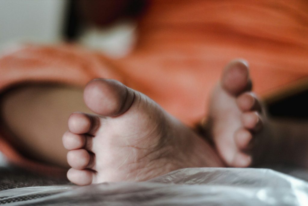 a close up of a person's bare feet on a bed