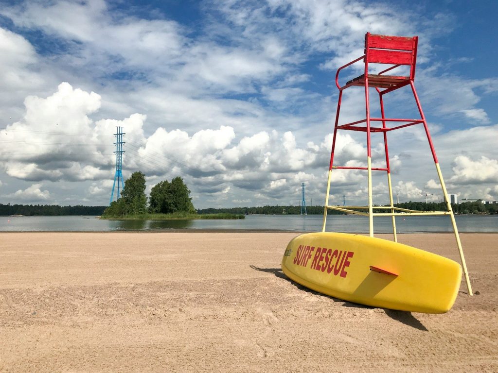 a lifeguard stand with a surfboard on the beach