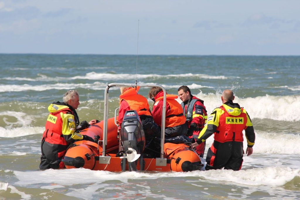 Coast guard team with orange rescue boat preparing for sea operation.
