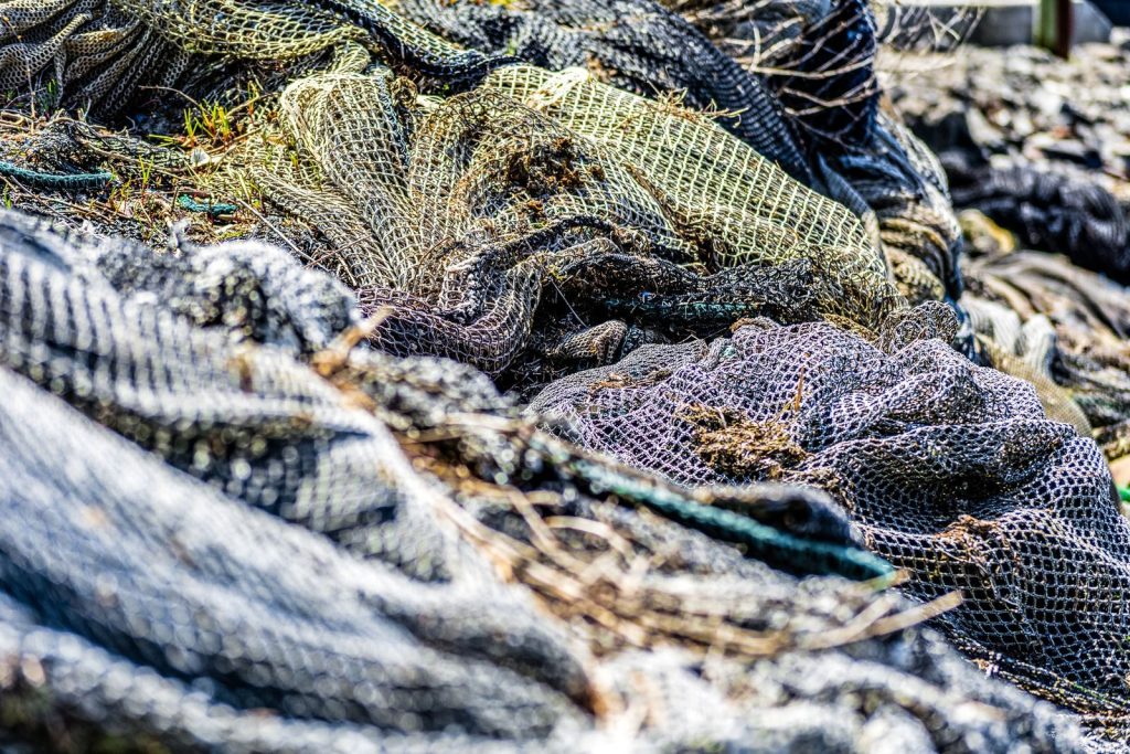 Detailed view of intertwined fishing nets with natural textures outdoors.
