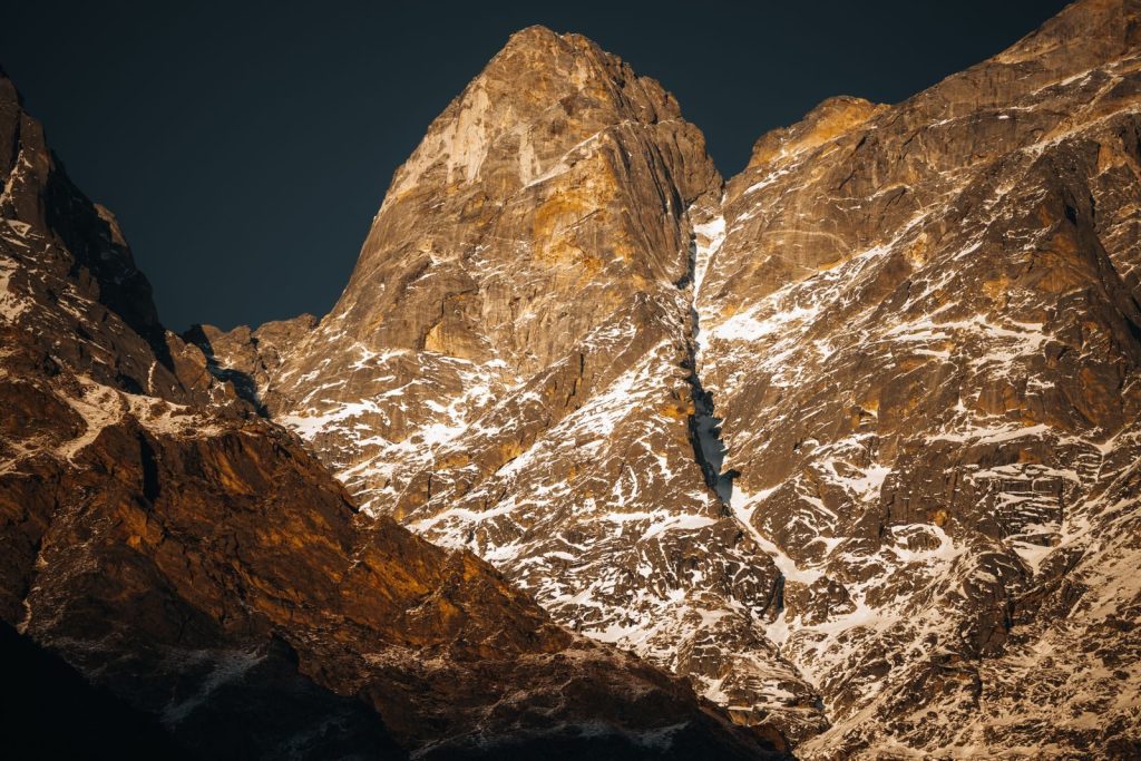 Stunning view of the Himalayan peaks during sunset, showcasing snow-covered rocky terrain.