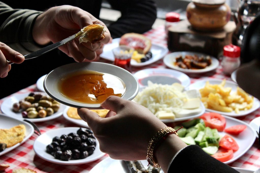 Close-up of hands sharing delicious Turkish breakfast. Warm and inviting.