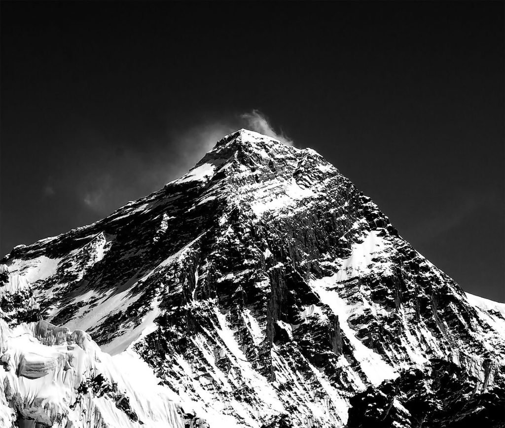 Black and white of high rocky mountain ridge covered with white snow in winter time