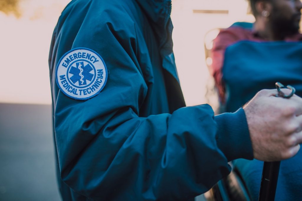 EMT assisting a patient, highlighting emergency medical services and care.
