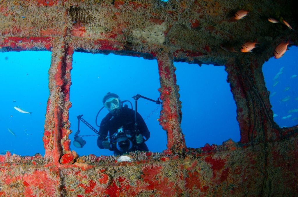 Scuba diver captures images at an underwater shipwreck.