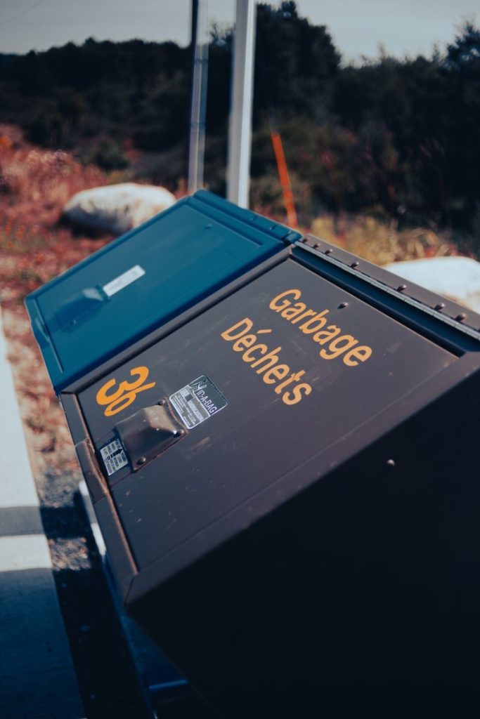 A recycling container in a natural setting promoting environmental awareness.